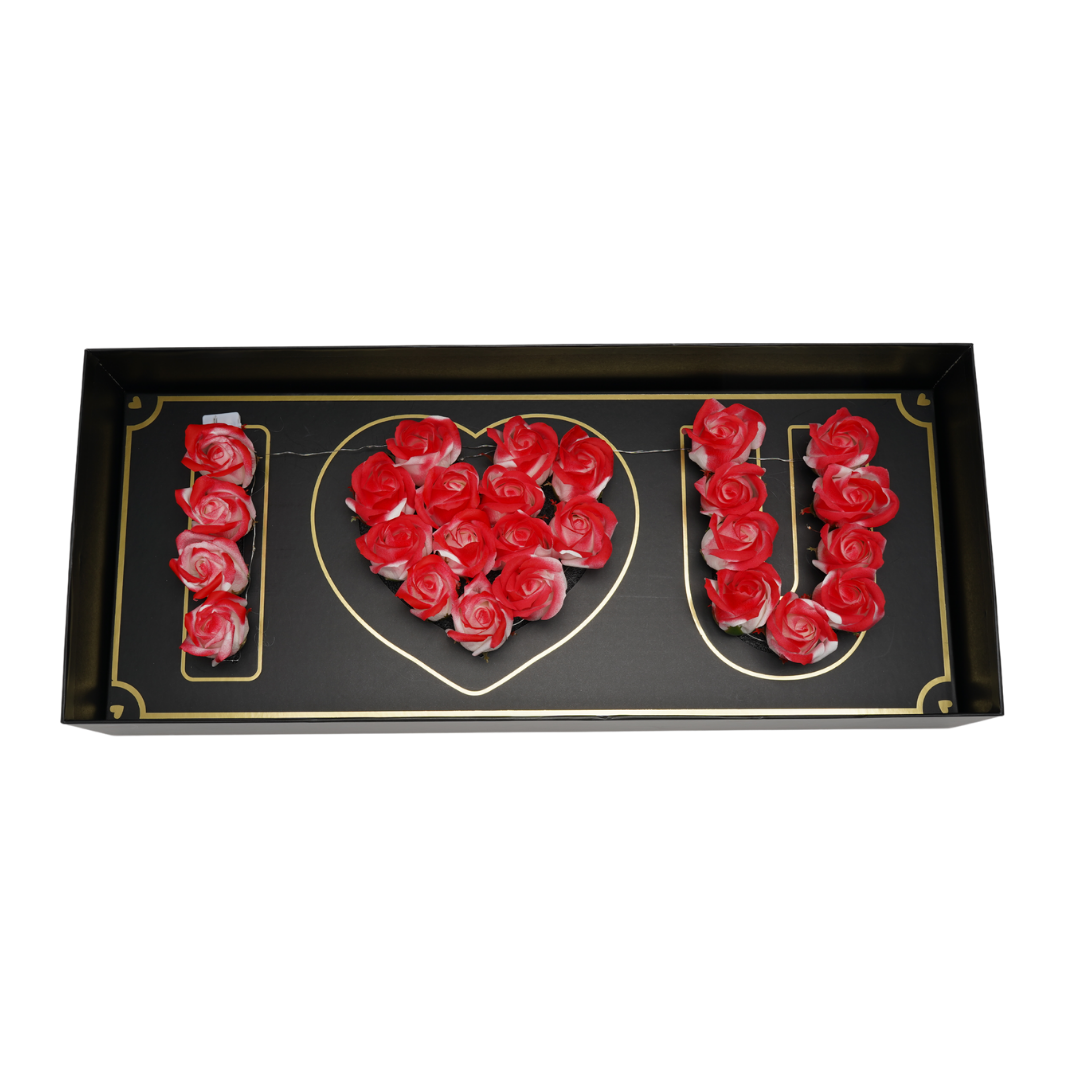 Black floral box with whitw/hyrbrid Eternal flowers that say I love you and has strings of small LED lights.